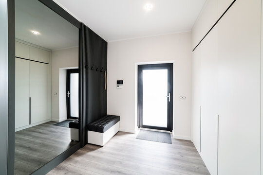 Large, bright corridor with a black closet and mirror