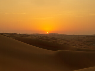Fototapeta na wymiar Romantic Desert Sunset in the Rub'al Khali Desert aka The Empty Quarter or Liwa Desert, endless sand dunes in the United Arab Emirates
