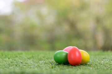 Colorful Easter eggs background. holiday, Easter background. Colorful Easter eggs on the green garden yard. symbol of Easter's day festival. vivid color natural background. festive wallpaper.