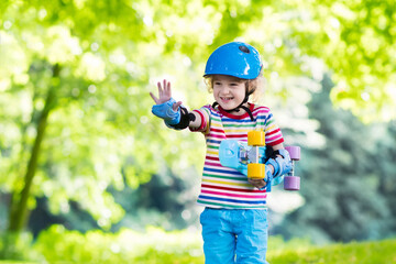 Child riding skateboard in summer park