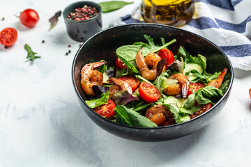 Fresh salad bowl with smoked shrimps, cherry tomatoes, cucumber and mixed leaves, Healthy food. Clean eating. top view