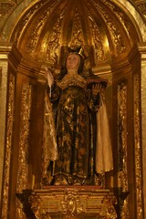 Richly embellished gilded Baroque wood sculpture of Saint Teresa of Avila, depicting the saint with her characteristic feather and book attributes at Jaen Cathedral, Jaén, Spain - obrazy, fototapety, plakaty