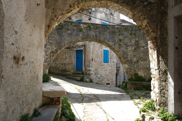 Fototapeta na wymiar Ancient abandoned medieval town Plomin, Istria Croatia. Old stone street with ruined walls houses and stairs.