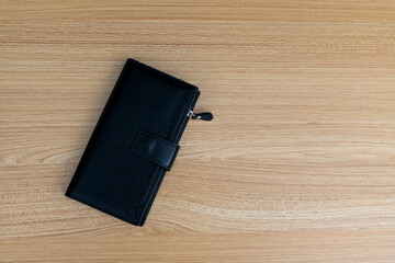 Black leather wallet on wooden table