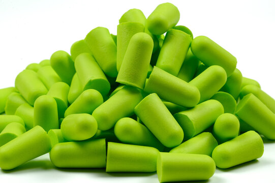 A bunch of light green earplugs,on a white background.Close-up.Soft foam earplug