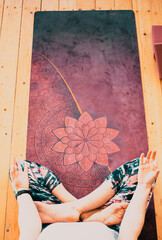 Fototapeta na wymiar top view of woman doing yoga at home sitting in Padmasana or lotus posture