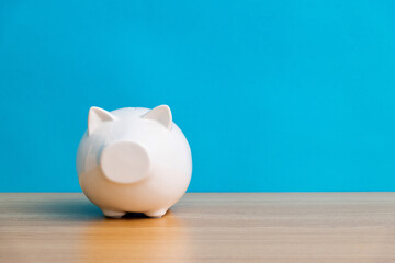 White piggy bank on wooden table