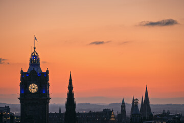 Fototapeta na wymiar Sunset sky over Edinburgh with the city's towers and rooftops. Blue Hour, Balmoral Clocktower, Edinburgh, Scotland, United Kingdom 