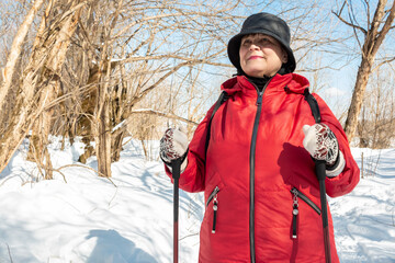 Nordic walking. Elderly woman walks in nature.