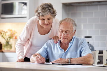 They were as sharp as we were in love. Shot of an elderly couple going over paperwork at home.