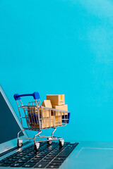 Shopping cart with boxes on laptop keyboard © xy