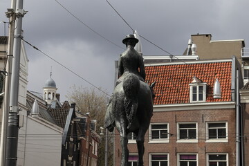 Amsterdam Rokin Street View with Equestrian Statue of Queen Wilhelmina, Brick Building Facades and Grey Sky, Netherlands