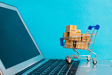 Shopping cart with boxes on laptop keyboard