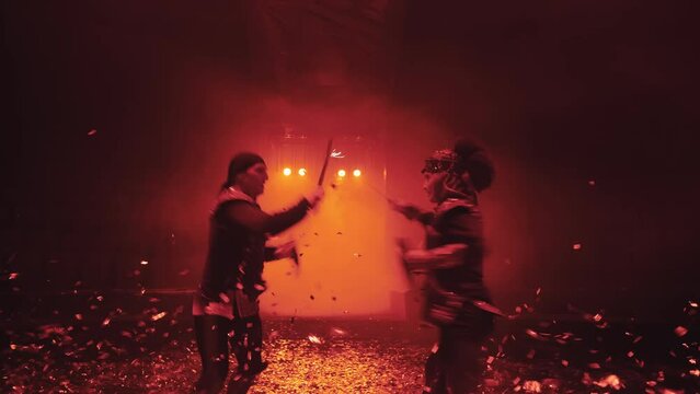 sword fight in the circus arena with beautiful red lighting in the fog, flying confetti, slow motion, two warriors fighting with swords, fencing, staged fight