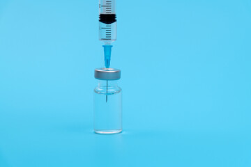 Syringe inserted into vaccine bottle