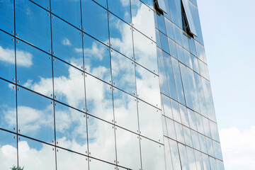 Fototapeta na wymiar Clouds reflected in modern office building wall