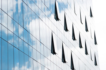 Clouds reflected in modern office building wall