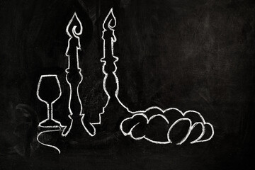 Jewish Shabbat symbols, wine cup for kiddush, two candlesticks with burning candles and challah. drawing on chalkboard