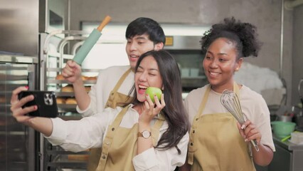 Students In Cookery Class Mixing Ingredients For Recipe In Kitchen.Group of young people taking selfie during cooking classes.