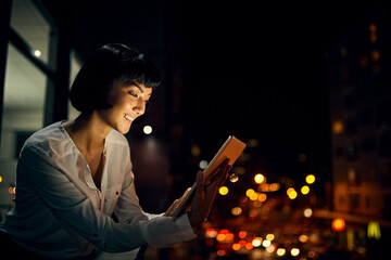 Staying in the know right through the night. Shot of an attractive young woman using a digital...