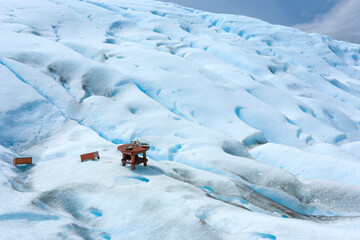 primo piano di un banchetto con alcolici per riscaldarsi e sullo sfondo il ghiacciaio della Patagonia 