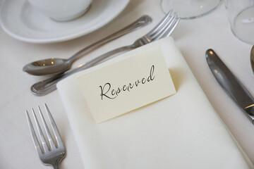 Reserved Sign at a Table Setting with White Tablecloth