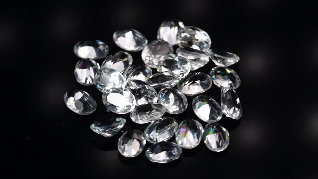 natural white topaz gemstones on the dark background turning table