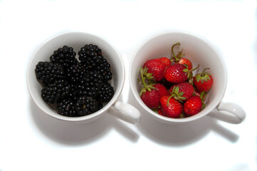 A cup of strawberries and a cup of blackberries. View from above. High quality photo