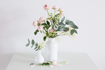 bouquet of pink roses in  two white vases  on white background