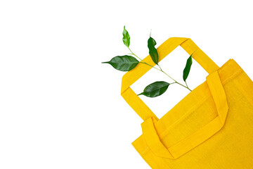 A yellow bag made of natural material and a green sprout isolated on a white background.