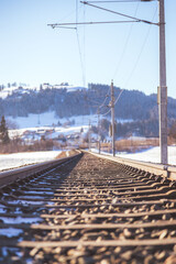 Sustainable traveling by train: Electric rail track in winter