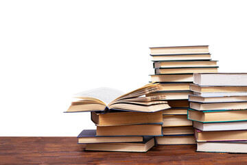 Three stacks of books and an open book on a wooden table, isolated on a white background.