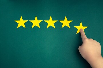 The customer's hand gives a five-star rating on a green background. The concept of service quality assessment.