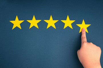 The customer's hand gives a five-star rating on a blue background. The concept of service quality assessment.