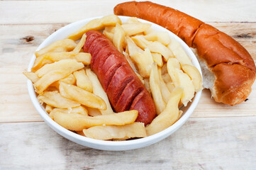 Popular and simple South African Fast food or street food , Russian sausage and Chips on a rustic surface

