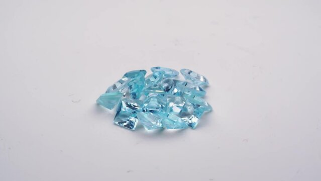 natural blue topaz gemstones on the white background turning table
