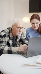 Old man learns to use computer while granddaughter helps him