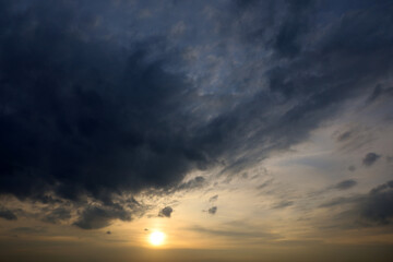 Obraz premium Sky covered with dark storm clouds and setting sun. Dramatic background for weather before rain at sunset