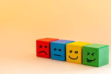 Smile and change your sad face, Colorful wooden blocks with painted human emotions, sadness turning...