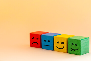 Smile and change your sad face, Colorful wooden blocks with painted human emotions, sadness turning into joy, Concept of choosing a positive attitude