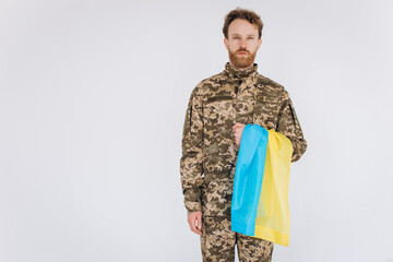 Ukrainian patriot soldier in military uniform holding a yellow and blue flag on a white background