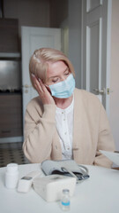 Elderly patient at the doctor's appointment. She complains of headaches while a female doctor fills out a questionnaire