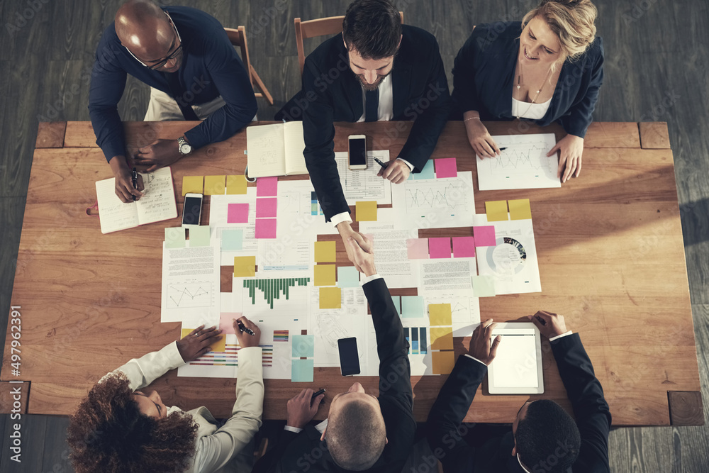 Poster starting new partnership is potential for success. high angle shot of a team of businesspeople worki