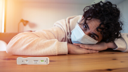 A sad caucasian man makes a test device for Covid19 virus with a positive result