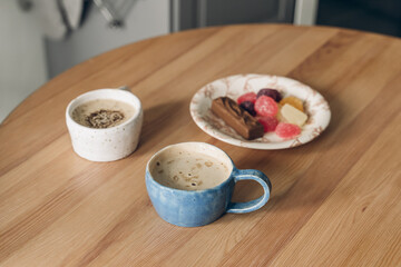 breakfast with coffee in the kitchen. wooden table in the kitchen. Scandinavian style. White wooden background. Bright kitchen interior. table setting for dinner. Coffee time.