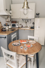 Sushi on wooden table in the kitchen. Scandinavian style. White wooden background. Bright kitchen interior. sushi with chopsticks. sushi on a plat. table setting for dinner. modern interior. 