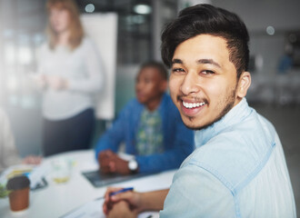 His ideas are a cut above the rest. Cropped portrait of a young businessman looking over his shoulder during a presentation in a boardroom.