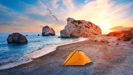 Orange tourist tent on beach of Aphrodite in Cyprusand seagull in sky - 497966533