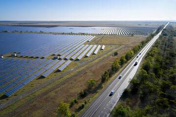 Aerial view of a solar power plant from a variety of photovoltaic panels. Next to the power plant...