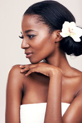 Fototapeta premium Her beauty just keeps on blossoming. Studio shot of a beautiful young woman with a flower in her hair.